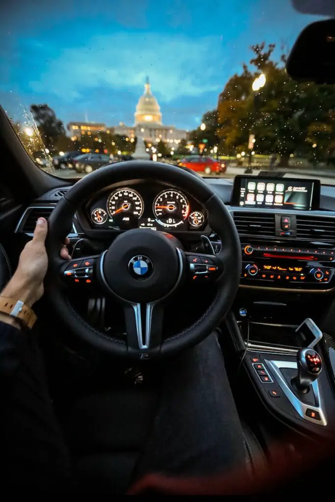 person holding bmw steering wheel