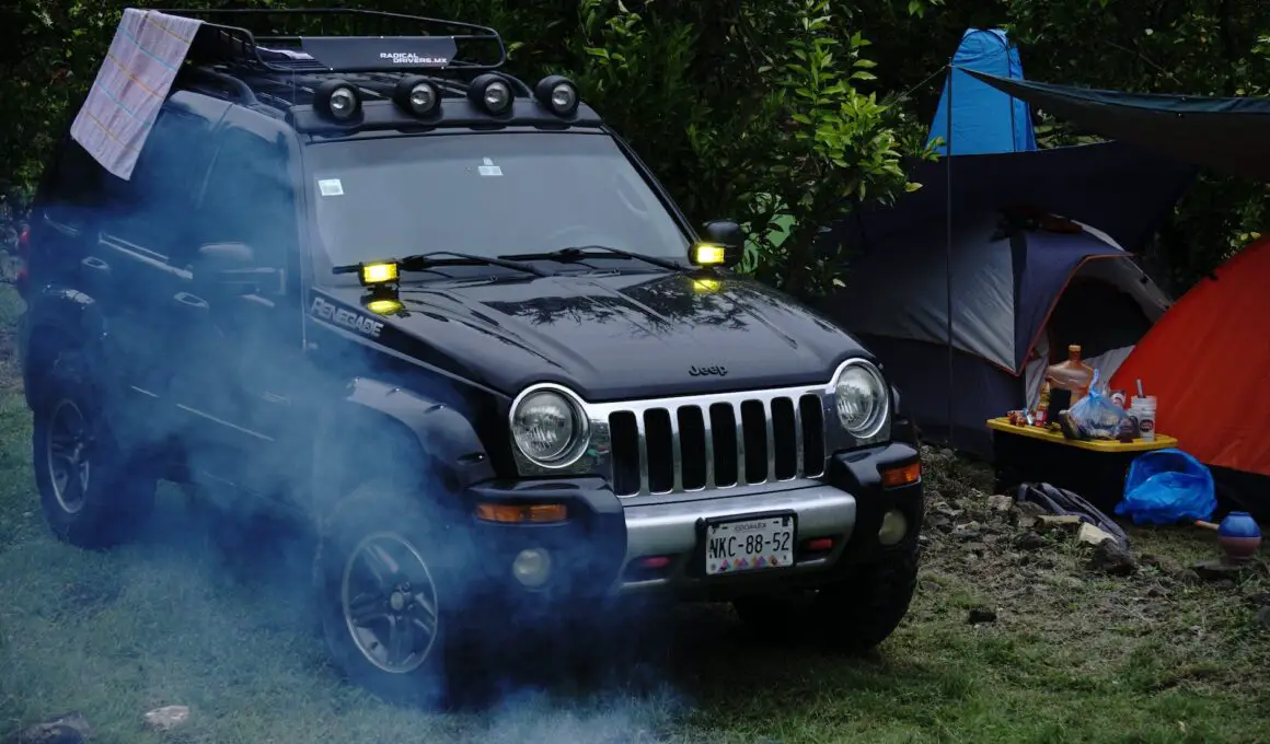 jeep by tents in forest